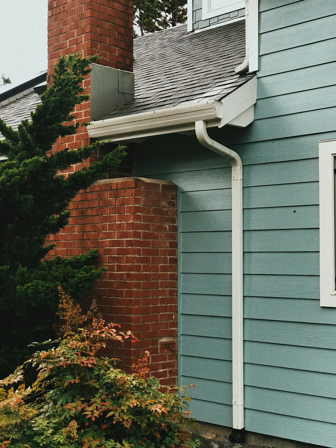 Residential gutter and downspout system along a roofline